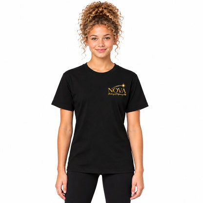 A woman with curly light brown hair wearing a black short-sleeve crewneck t-shirt with a gold 'NOVA Dance of Fireworks 2025' logo on the left chest, paired with black leggings, against a solid light gray studio background.