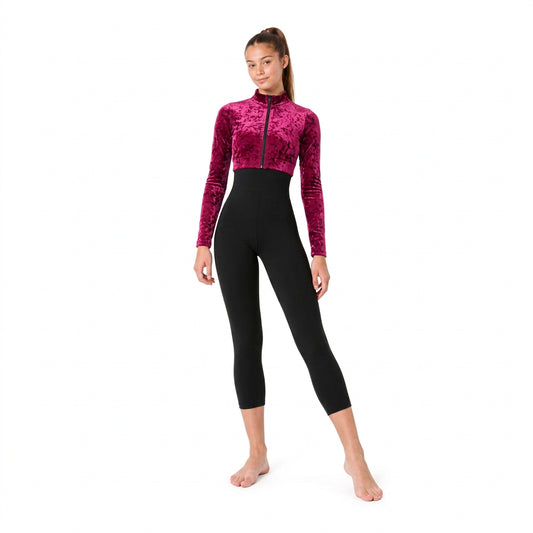 A woman modeling a one-piece jumpsuit with a royal blue velvet long-sleeve top and a black high-waisted, form-fitting legging bottom, shown against a plain white background.