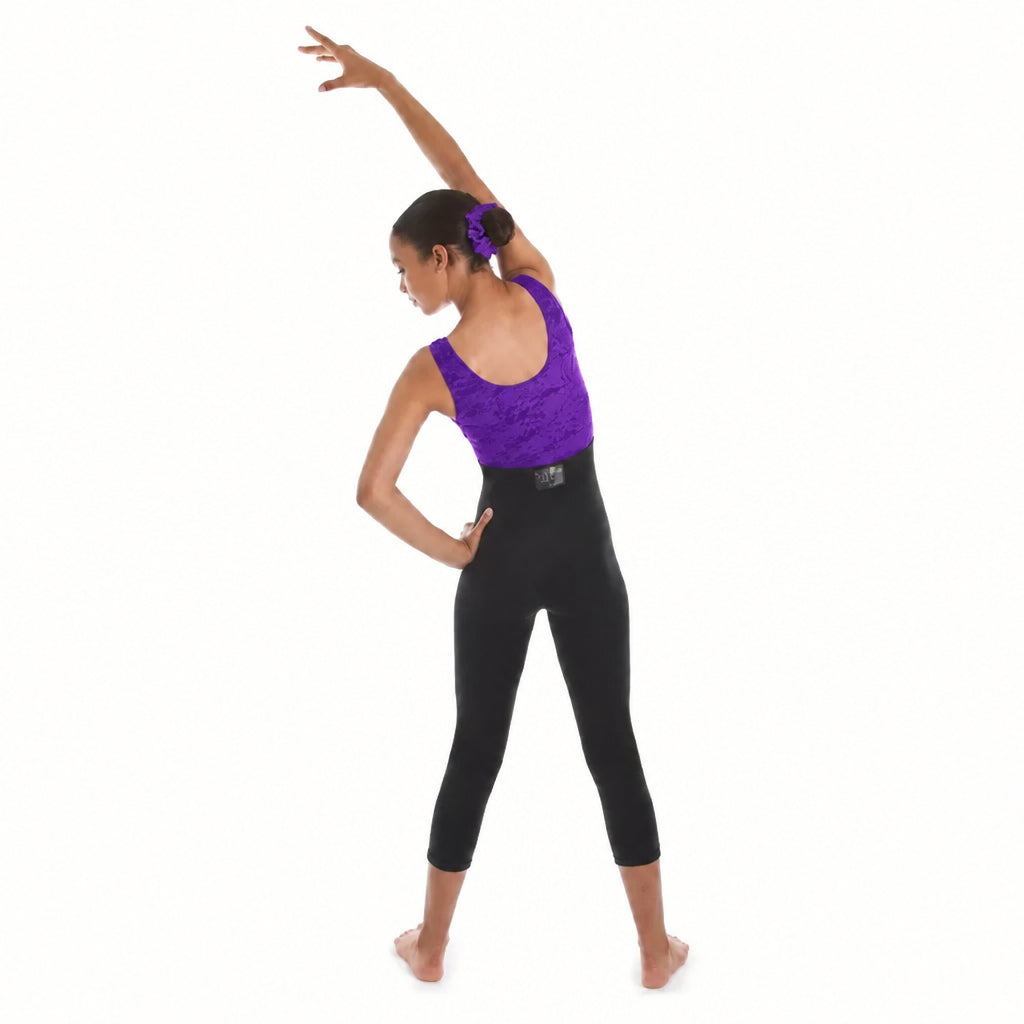 A woman modeling a two-piece activewear set consisting of a purple sleeveless scoop-neck top and black high-waisted capri leggings, shown from a side-back profile against a solid white background.