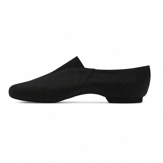 A single black slip-on loafer-style shoe shown in side profile against a warm beige textured background.